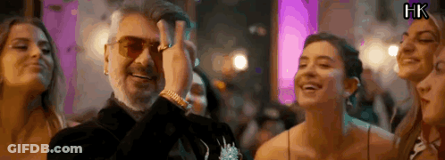 A Man With A Beard Is Standing In A Crowd Of People . GIF