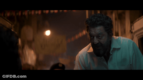 A Man With A Beard Is Standing In A Dark Alleyway With The Word Dard Written On The Bottom GIF