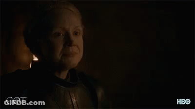 A Man With A Beard Is Standing In A Dark Room With The Word Got Written On The Bottom GIF