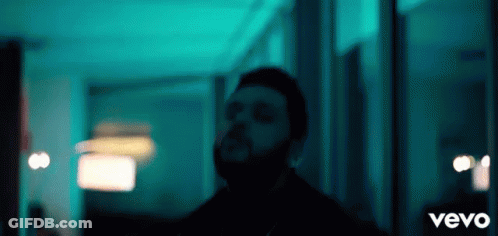 A Man With A Beard Is Standing In A Dark Room With The Word Vevo On The Bottom GIF