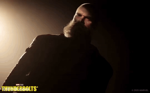 Bearded Man Standing In Dark Room With Thunderbolts GIF
