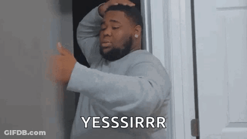 A Man With A Beard Is Standing In A Doorway Holding His Head And Giving A Thumbs Up . GIF