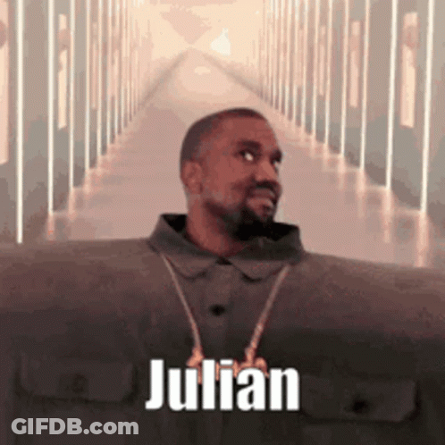 A Man With A Beard Is Standing In A Hallway With The Name Julian On It . GIF