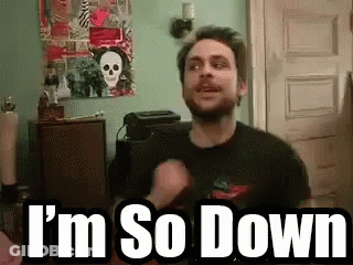 A Man With A Beard Is Standing In A Room With The Words `` I 'M So Down '' Written On The Screen . GIF