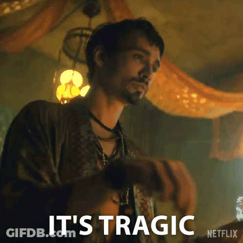 A Man With A Beard Is Standing In A Room With The Words `` It 'S Tragic '' Written On The Bottom . GIF