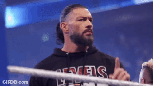 A Man With A Beard Is Standing In A Wrestling Ring And Giving The Middle Finger . GIF