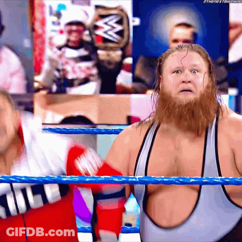 A Man With A Beard Is Standing In A Wrestling Ring With A W Logo In The Background GIF
