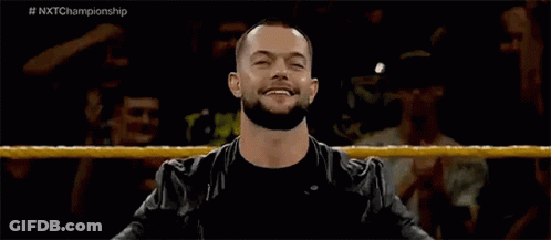 A Man With A Beard Is Standing In A Wrestling Ring With His Arms Outstretched . GIF