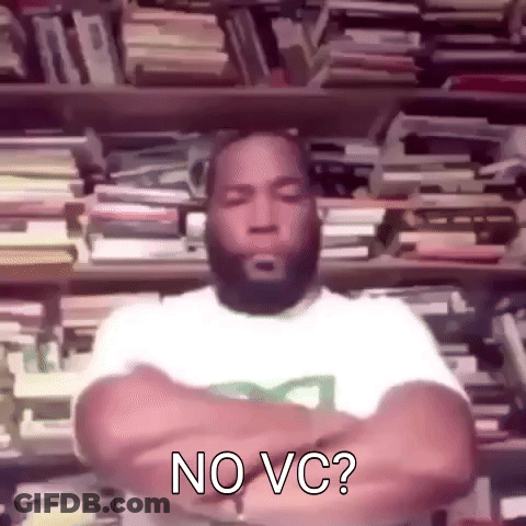 A Man With A Beard Is Standing In Front Of A Bookshelf With His Arms Crossed And Says No Vc . GIF