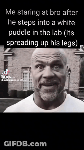 A Man With A Beard Is Standing In Front Of A Brick Building And Talking To Someone . GIF