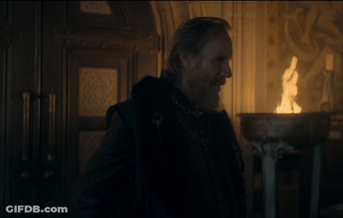 A Man With A Beard Is Standing In Front Of A Candle GIF