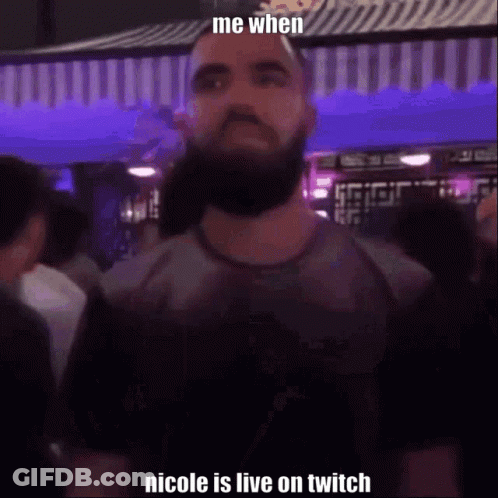 A Man With A Beard Is Standing In Front Of A Crowd In A Club . GIF