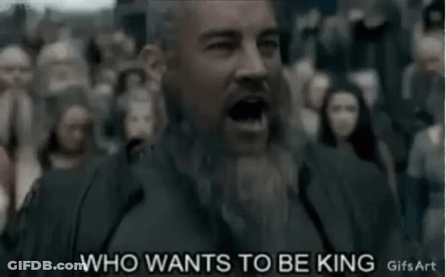 A Man With A Beard Is Standing In Front Of A Crowd Of People And Yelling . GIF