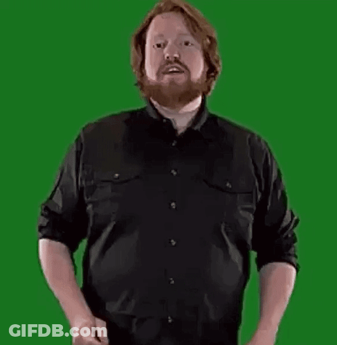 A Man With A Beard Is Standing In Front Of A Green Screen Holding A Large Letter B . GIF
