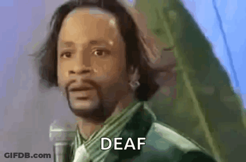 A Man With A Beard Is Standing In Front Of A Microphone And Says Deaf . GIF