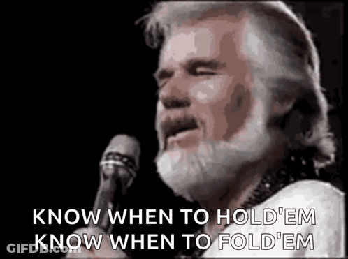 A Man With A Beard Is Standing In Front Of A Microphone And Singing . GIF