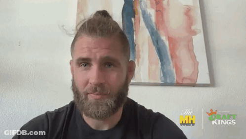 A Man With A Beard Is Standing In Front Of A Painting That Says Draft Kings On It GIF