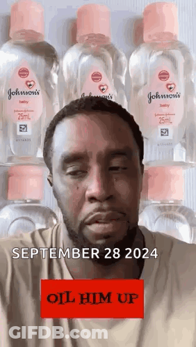 A Man With A Beard Is Standing In Front Of A Row Of Bottles Of Johnson 'S Baby Oil . GIF
