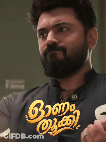 A Man With A Beard Is Standing In Front Of A Sign That Says ' Aa ' On It GIF