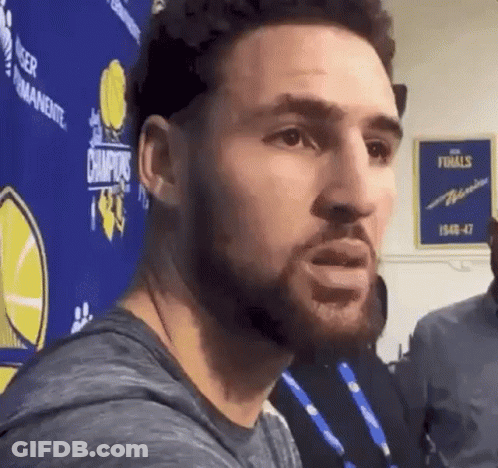 A Man With A Beard Is Standing In Front Of A Sign That Says Champions GIF