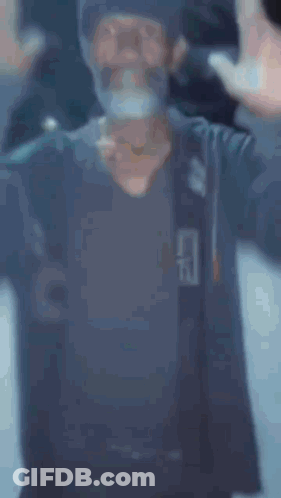 A Man With A Beard Is Standing In Front Of A Sign That Says " Expansion " GIF