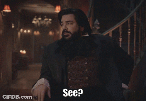 A Man With A Beard Is Standing In Front Of A Staircase And Says " See " GIF