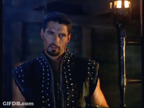 A Man With A Beard Is Standing In Front Of A Torch With The Words Still Picking Up On Me After All These Years Below Him GIF