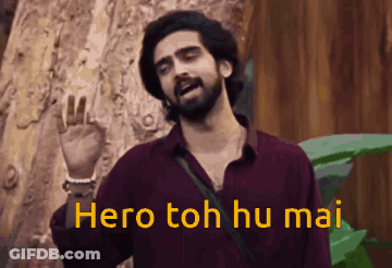A Man With A Beard Is Standing In Front Of A Tree And Says Hero Toh Hu Mai . GIF