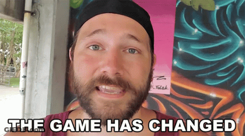 A Man With A Beard Is Standing In Front Of A Wall That Says The Game Has Changed On It GIF