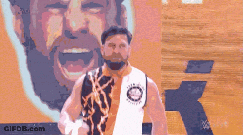 A Man With A Beard Is Standing In Front Of A Wall That Says Wwe On It GIF