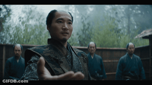 A Man With A Beard Is Standing In Front Of Three Other Men GIF