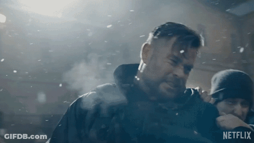 A Man With A Beard Is Standing In The Snow With A Netflix Logo In The Corner . GIF