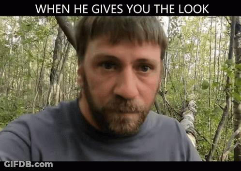 A Man With A Beard Is Standing In The Woods With A Caption That Says When He Gives You The Look GIF