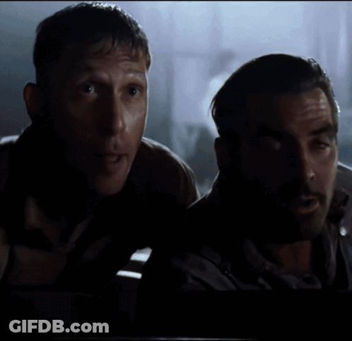 A Man With A Beard Is Standing Next To Another Man GIF