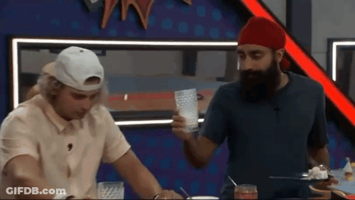 A Man With A Beard Is Standing Next To Another Man Who Is Holding A Glass GIF