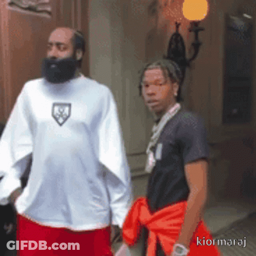 A Man With A Beard Is Standing Next To Another Man With A Necklace Around His Neck GIF