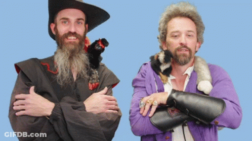 A Man With A Beard Is Standing Next To Another Man With A Purple Jacket GIF