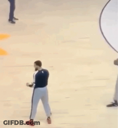A Man With A Beard Is Standing On A Basketball Court With Another Man . GIF
