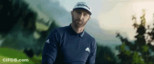 A Man With A Beard Is Standing On A Golf Course Holding A Golf Club . GIF