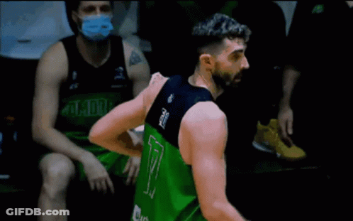 A Man With A Beard Is Standing On A Trampoline With A Towel Around His Waist . GIF