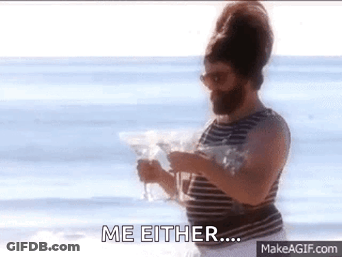 A Man With A Beard Is Standing On The Beach Holding A Martini And Says Me Either GIF