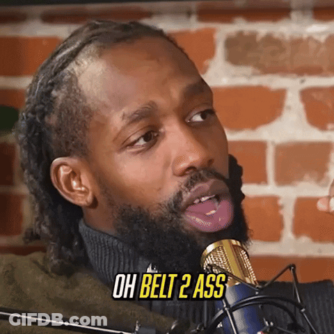 A Man With A Beard Is Sticking His Tongue Out In Front Of A Microphone And Says Oh Belt 2 Ass . GIF