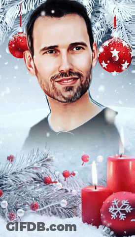 A Man With A Beard Is Surrounded By Candles And Christmas Decorations GIF