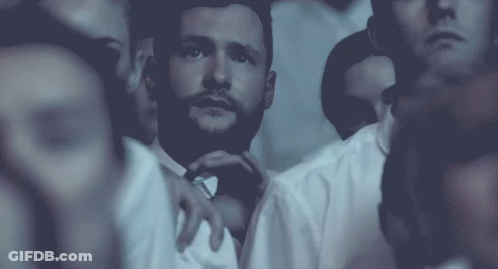 A Man With A Beard Is Surrounded By Other People In White Shirts GIF