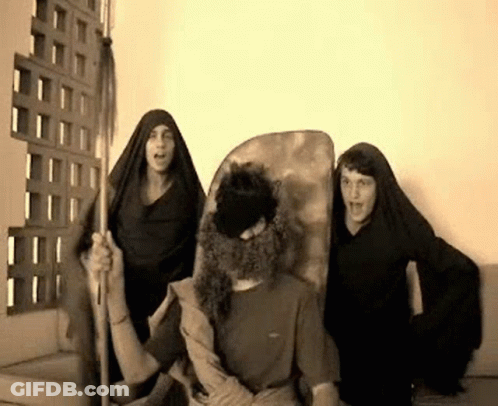 A Man With A Beard Is Surrounded By Two Women In Black Robes GIF