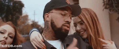A Man With A Beard Is Surrounded By Two Women . GIF