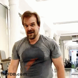 A Man With A Beard Is Sweating In A Gym While Wearing A T-Shirt . GIF