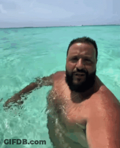 A Man With A Beard Is Swimming In The Ocean . GIF