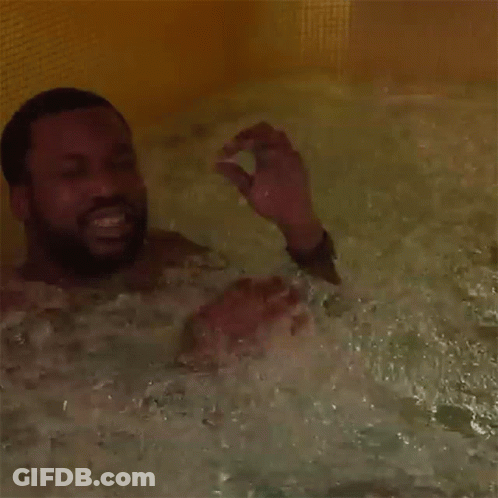 A Man With A Beard Is Taking A Bath In A Bathtub GIF