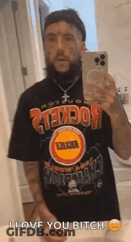 A Man With A Beard Is Taking A Selfie In A Bathroom Mirror . GIF